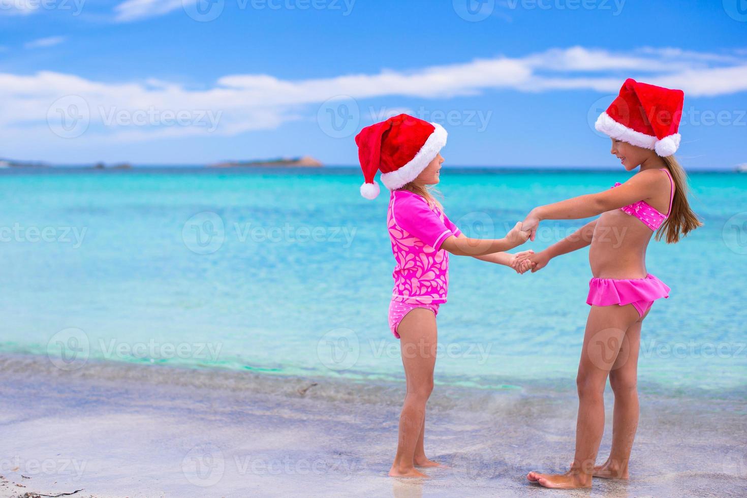 Little girls in Santa hats during summer vacation photo