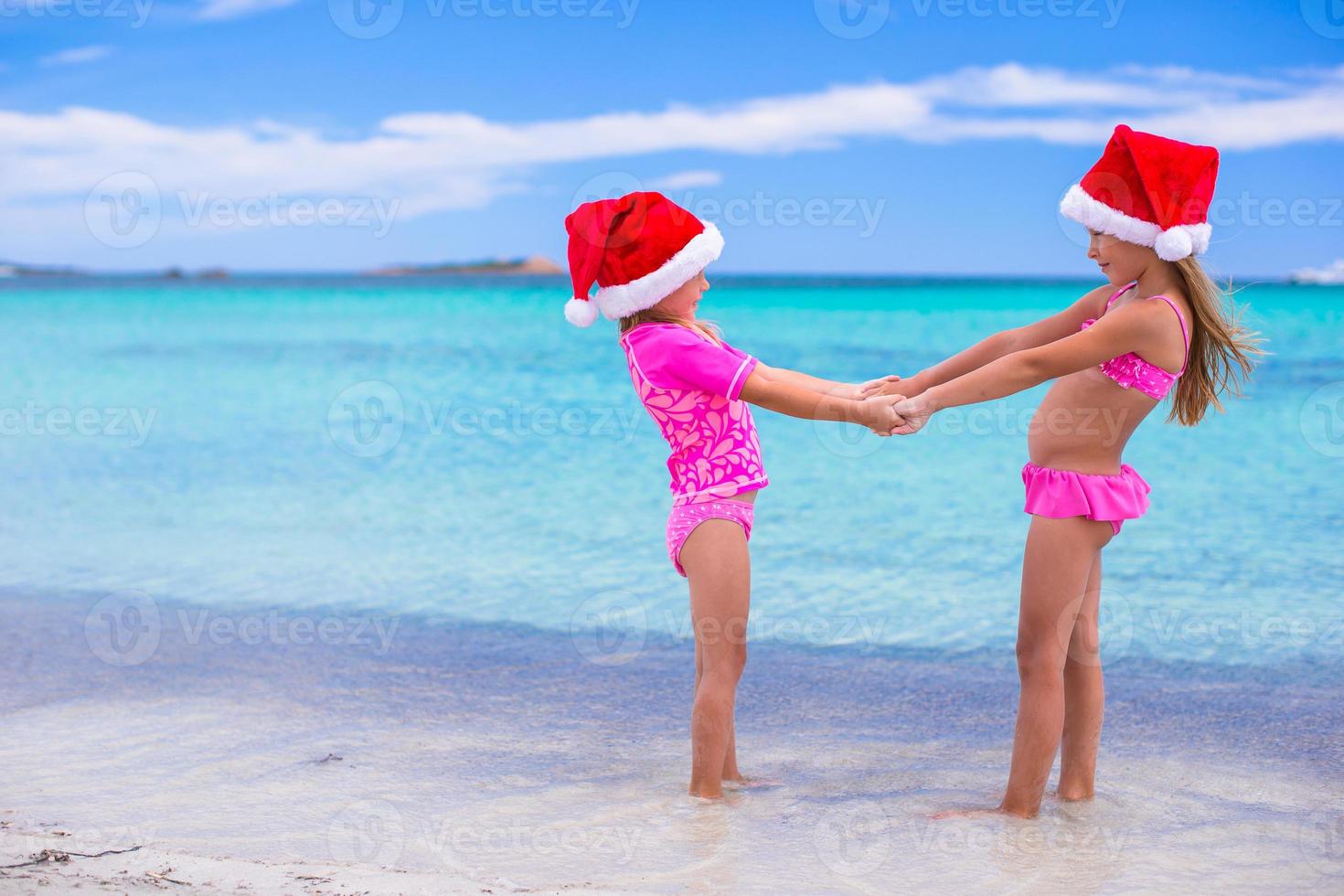 Little girls in Santa hats during summer vacation photo