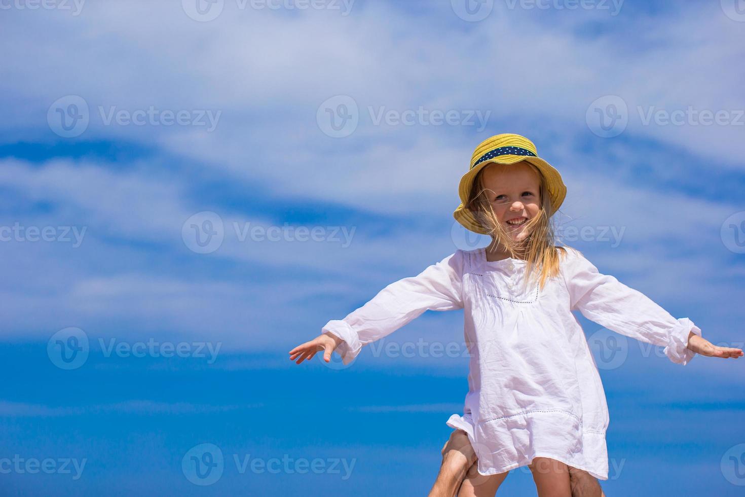 Adorable little girl at tropical beach during vacation photo