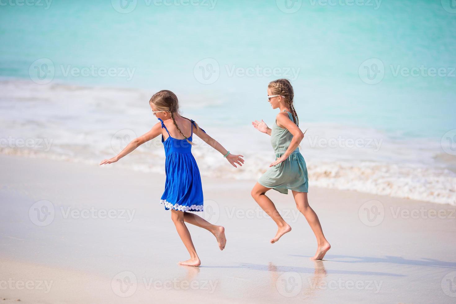 Kids having fun at tropical beach during summer vacation playing together photo