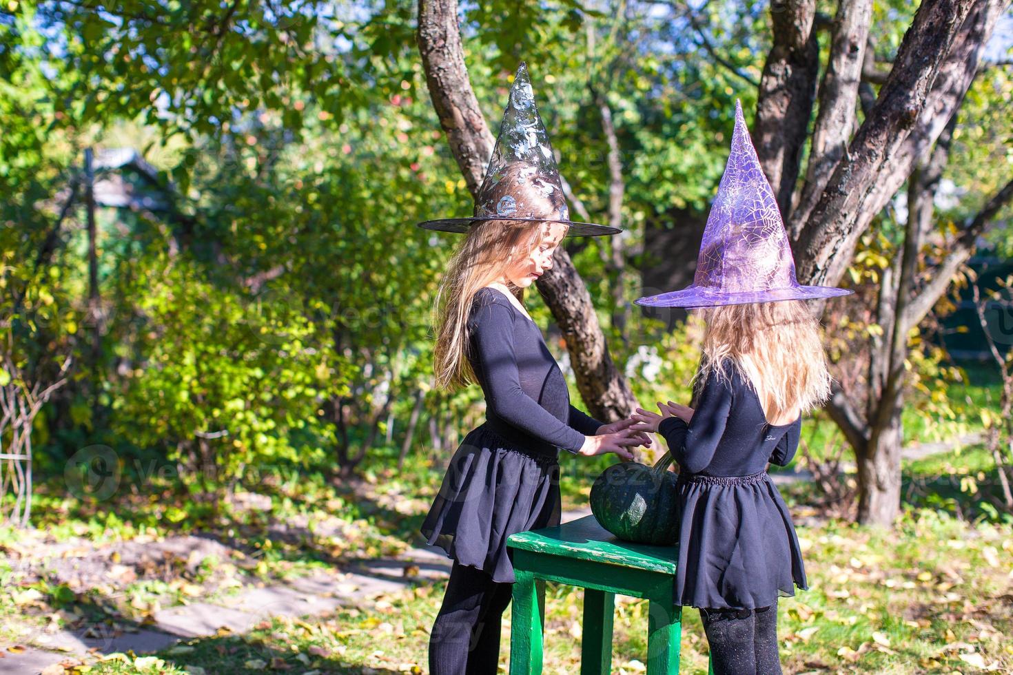 Niñas lanzando un hechizo en Halloween disfrazadas de brujas. foto