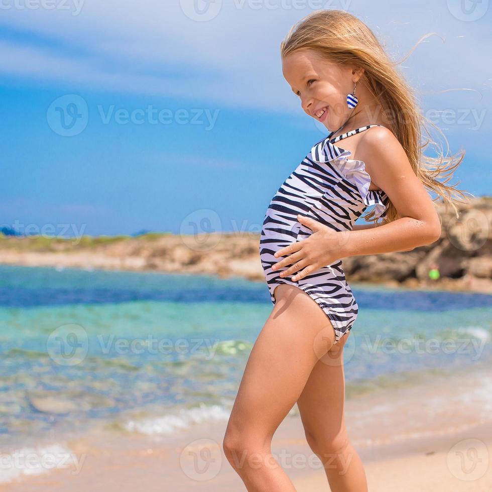 Adorable little girl have fun at tropical beach photo