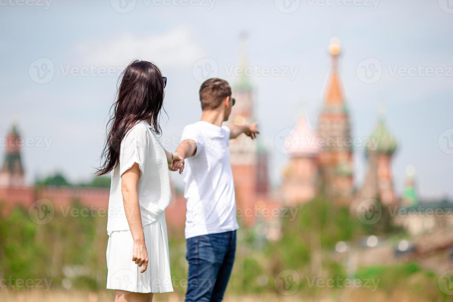 joven pareja enamorada caminando en el fondo de la ciudad iglesia de st basils foto