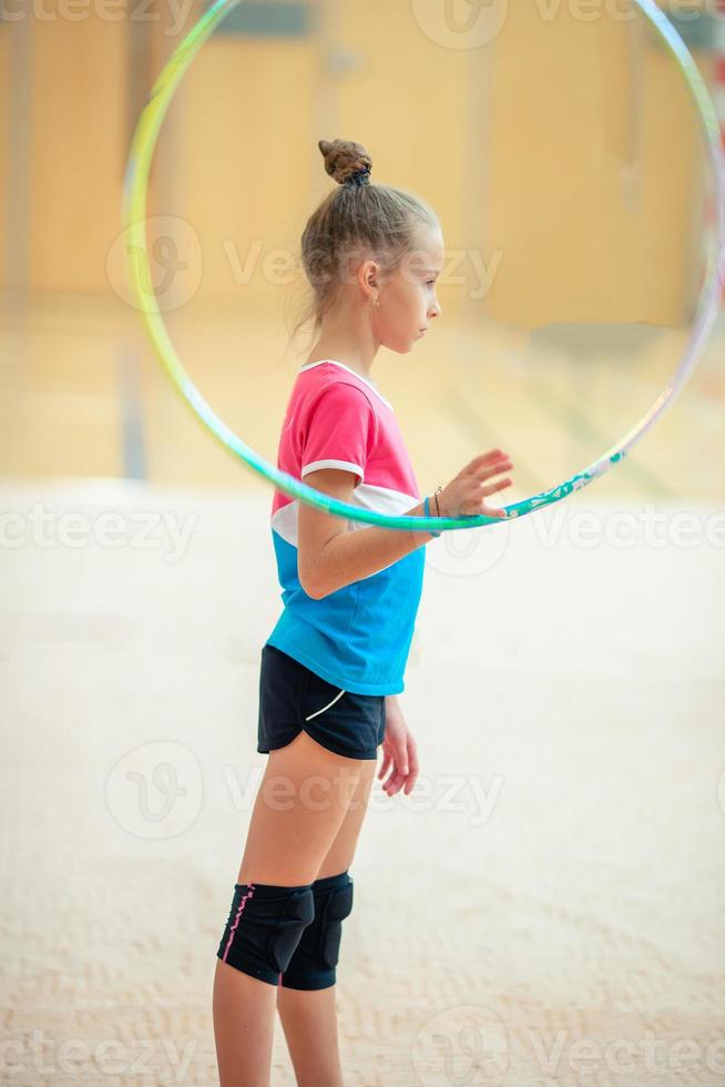 Beautiful little active gymnast girl with her performance on the carpet photo