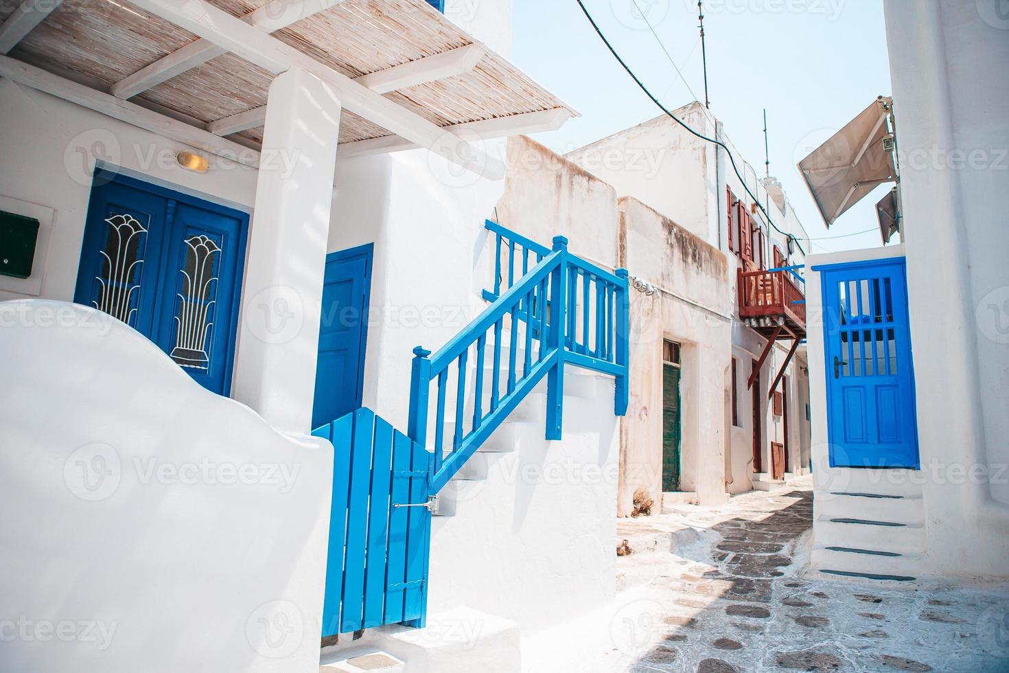 las estrechas calles de la isla con balcones azules, escaleras y flores en grecia. foto