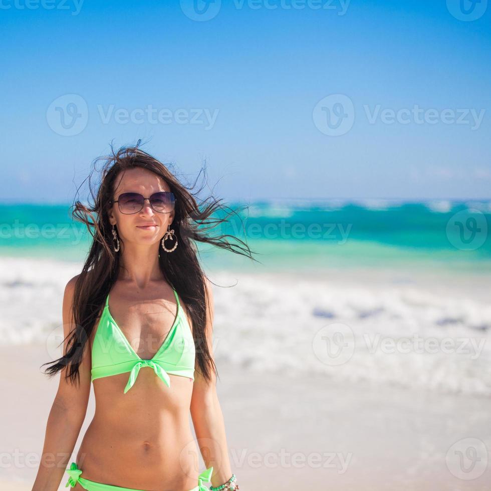 Portrait of Young woman enjoying the holiday on a white, tropical beach at sunny day photo