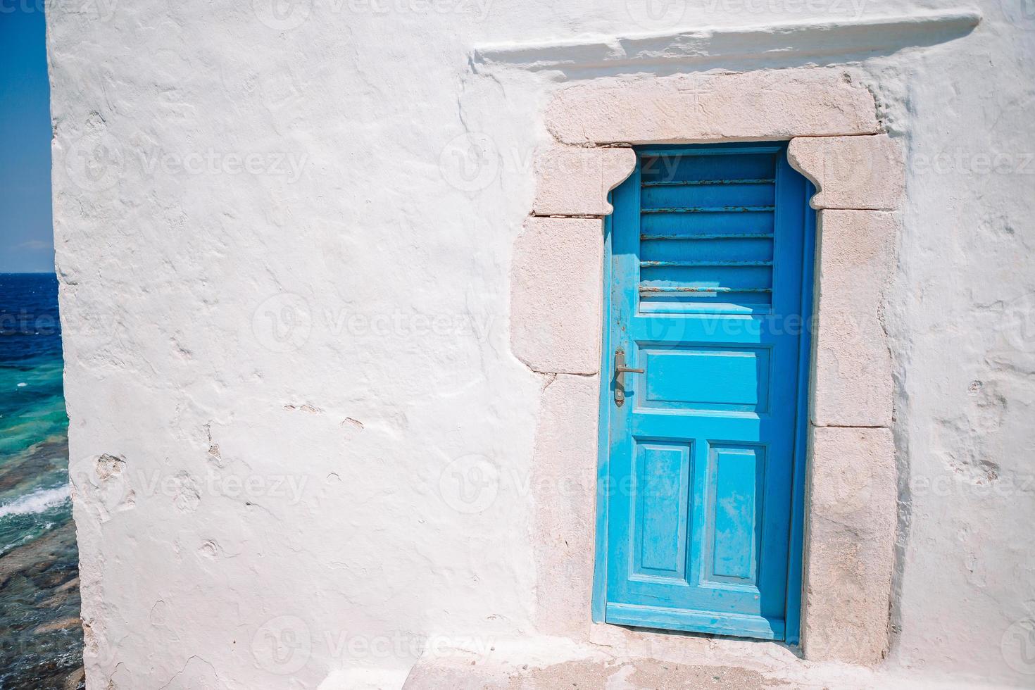 Traditional houses withe blue doors in the narrow streets of Mykonos, Greece. photo