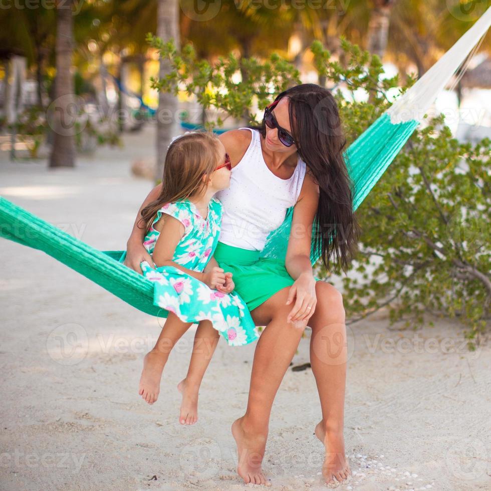 Young mommy and little girl on tropical vacation relaxing in hammock photo