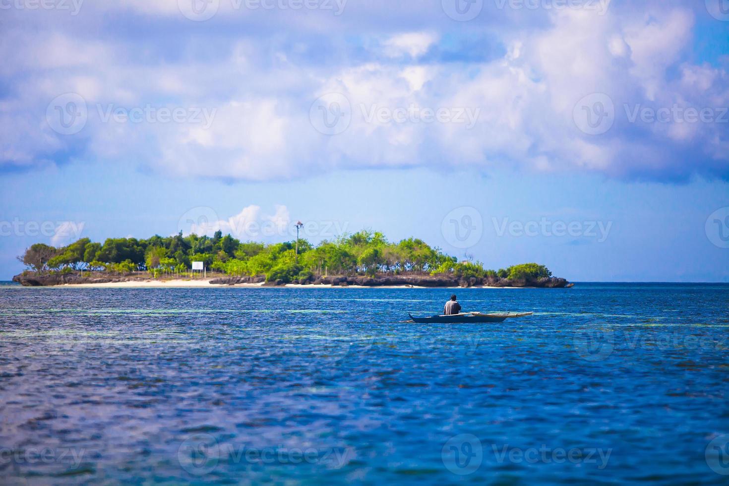 pobre pescador en barco en el mar azul claro de Filipinas foto