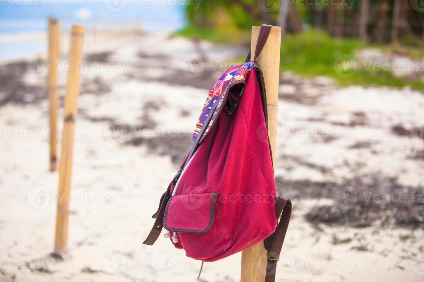 Red backpack at the fence n a deserted tropical island photo