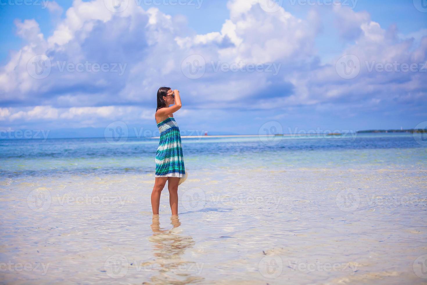 Young woman enjoying the holiday on a white, tropical beach at sunny day photo