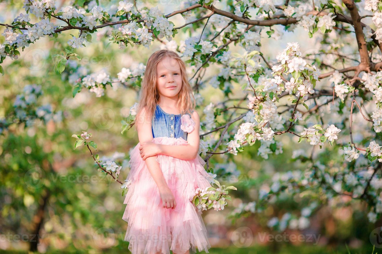 Cute girl in blooming apple tree garden enjoy the warm day photo