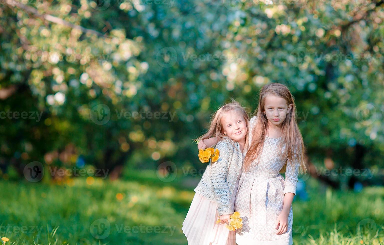 Adorable little girls on spring day outdoors photo