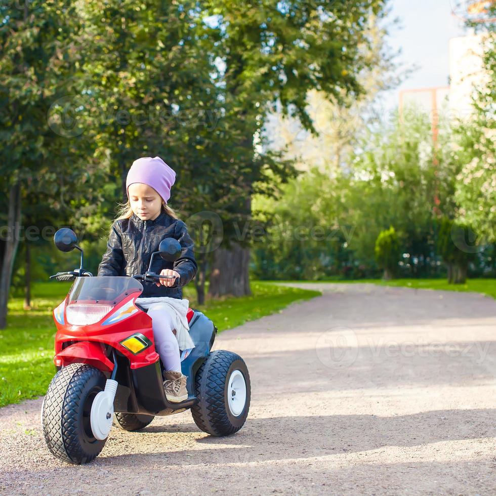 adorable niña montando una bicicleta para niños foto