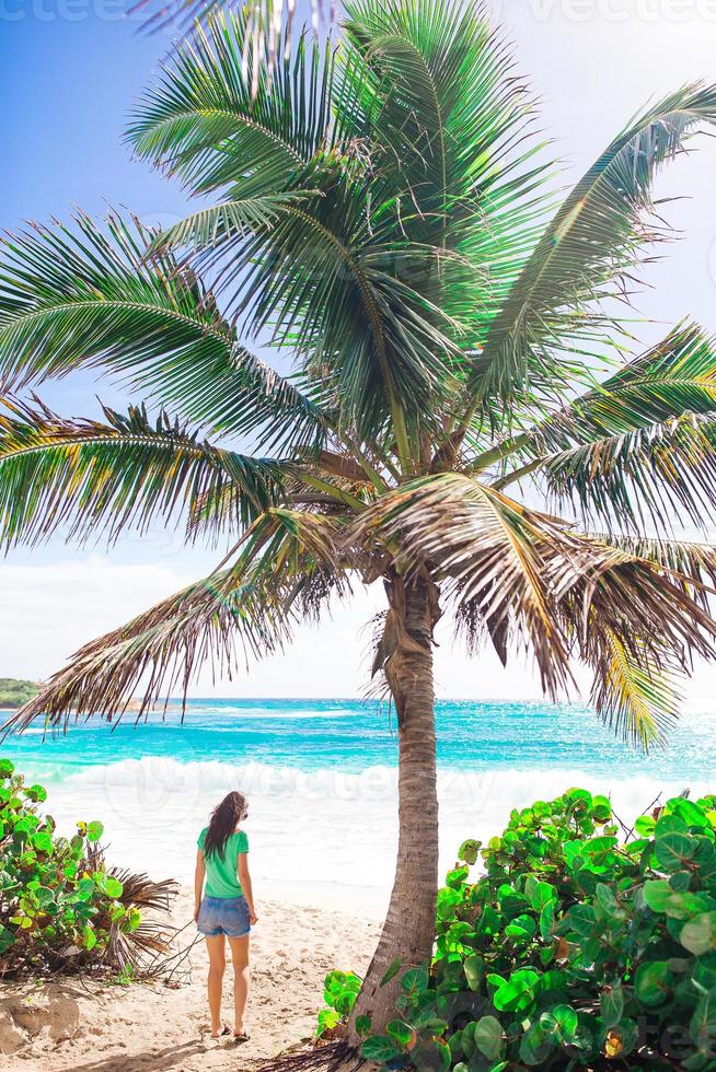 Young beautiful woman on white sand tropical beach. Caucasian girl with hat background the sea photo