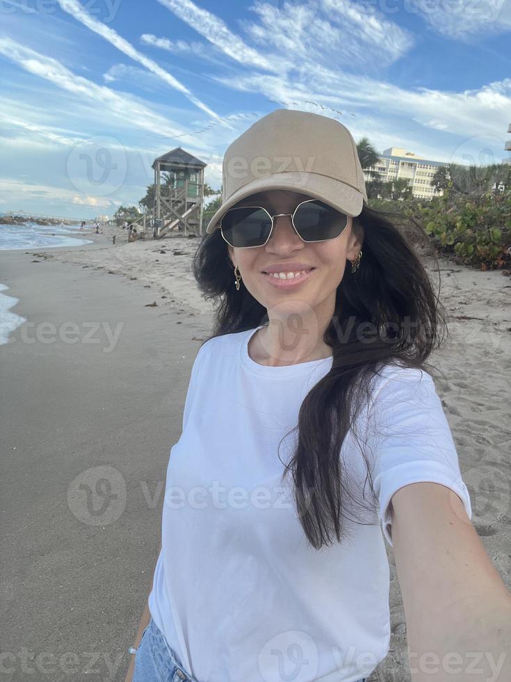 Young beautiful woman taking selfie on the beach photo