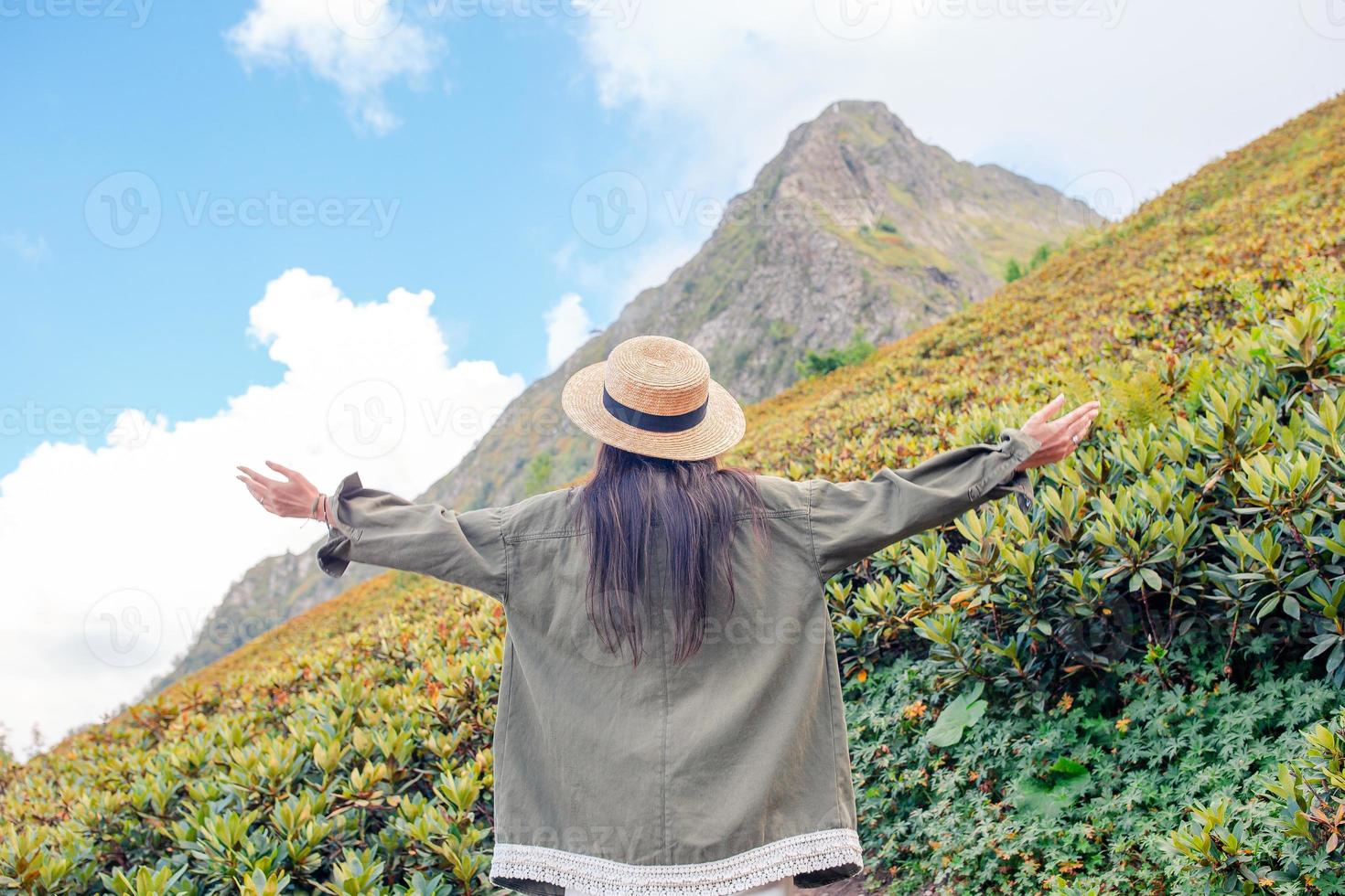 Beautiful happy young woman in mountains in the background of fog photo