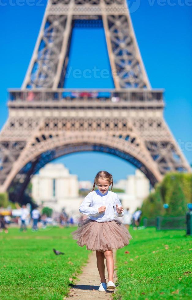 adorable niña cerca de la torre eiffel durante las vacaciones de verano en parís foto