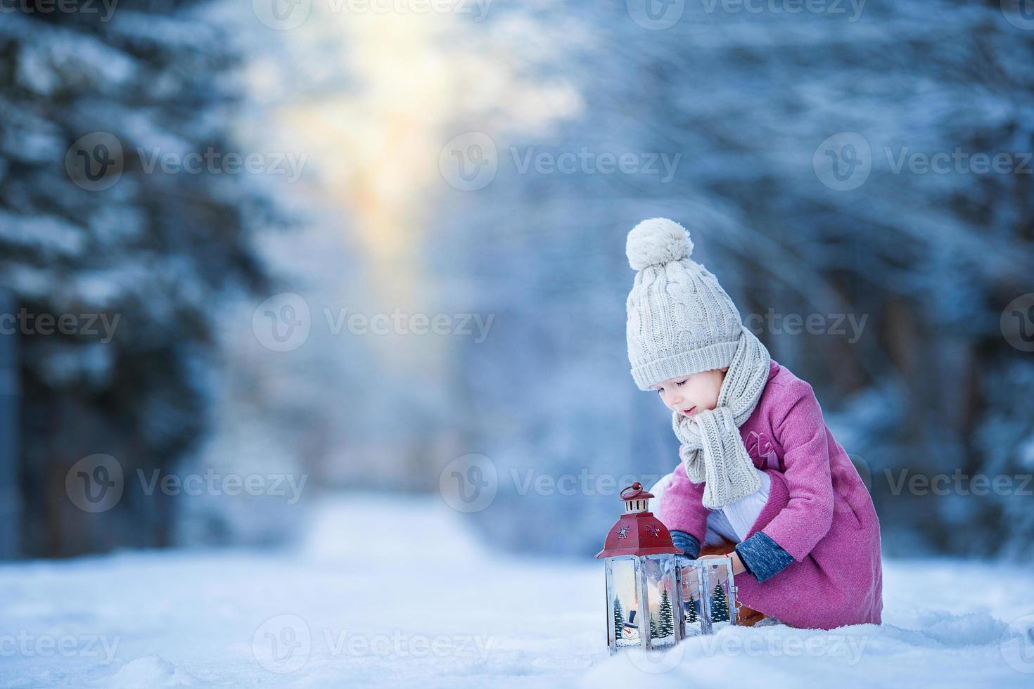 adorable niña con linterna en invierno congelado en navidad al aire libre foto