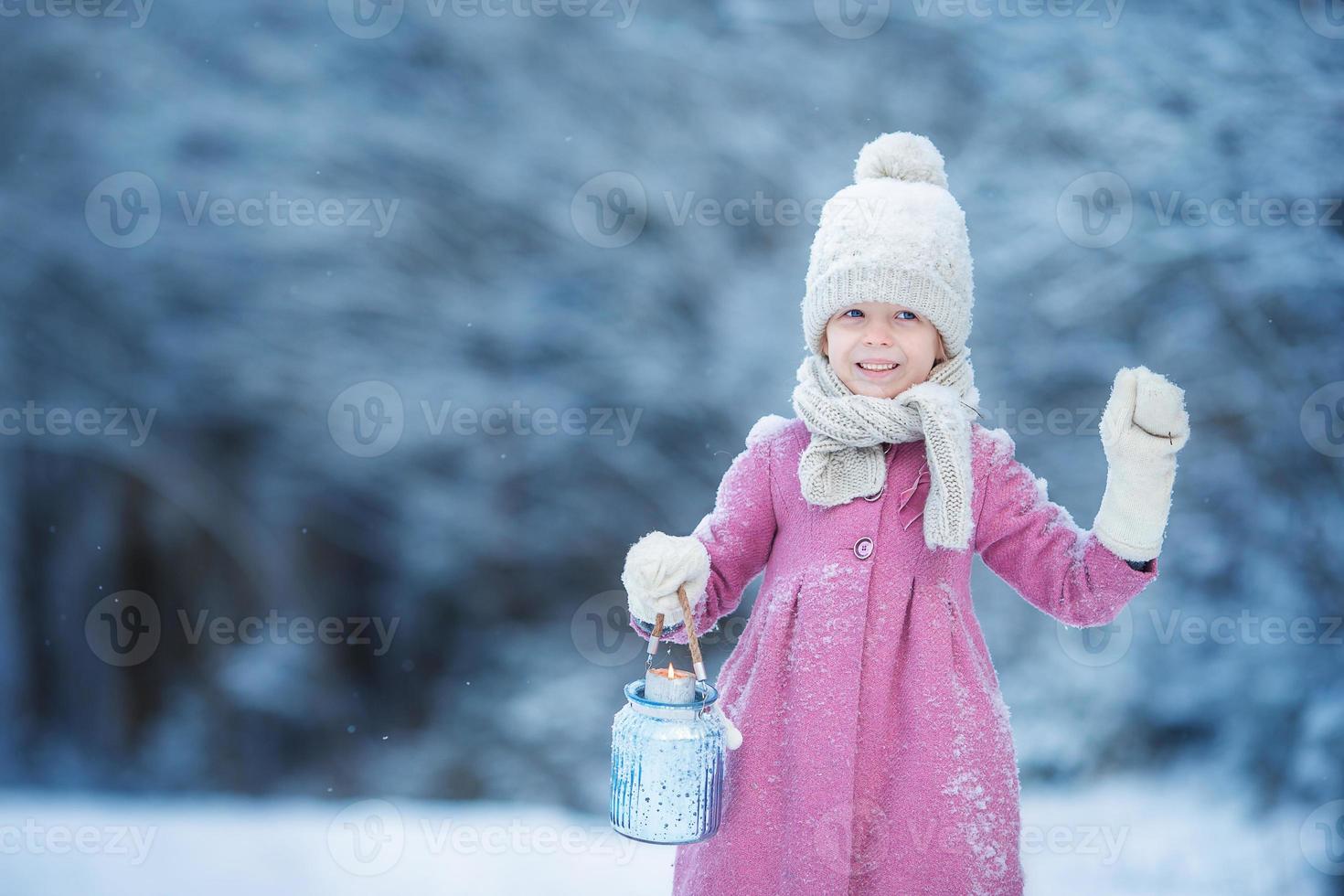 Adorable little girl with flashlight in cold day on Christmas outdoors photo