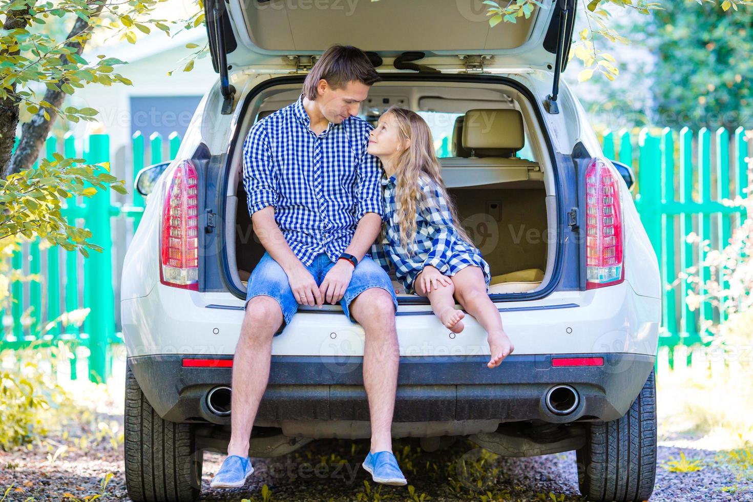 Little girl with dad sitting in a car just before leaving for a car vacation photo