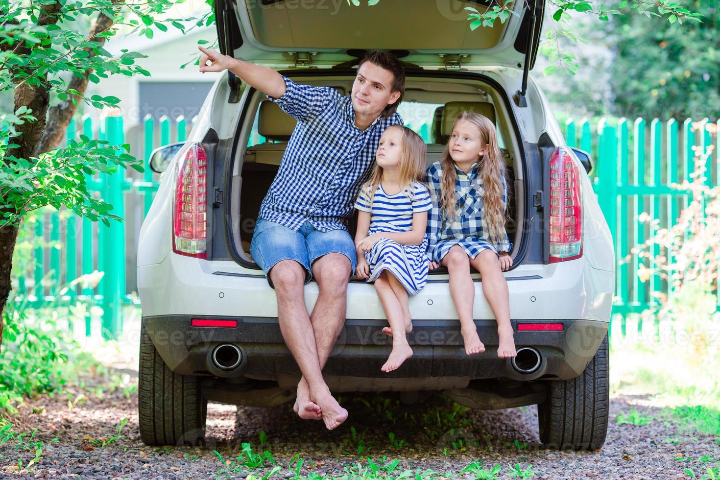 Father with kids sitting in car while traveling photo