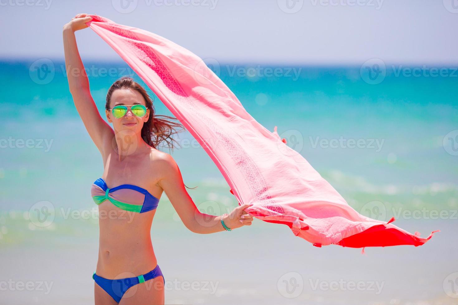 Young woman with beach towel during tropical vacation. Beautiful girl enjoy her summer holidays. photo