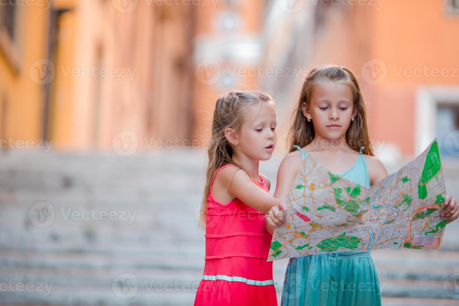 Adorable little girl looking at touristic map in roman streets in Italy. Happy toodler kids enjoy italian vacation holiday in Europe. photo