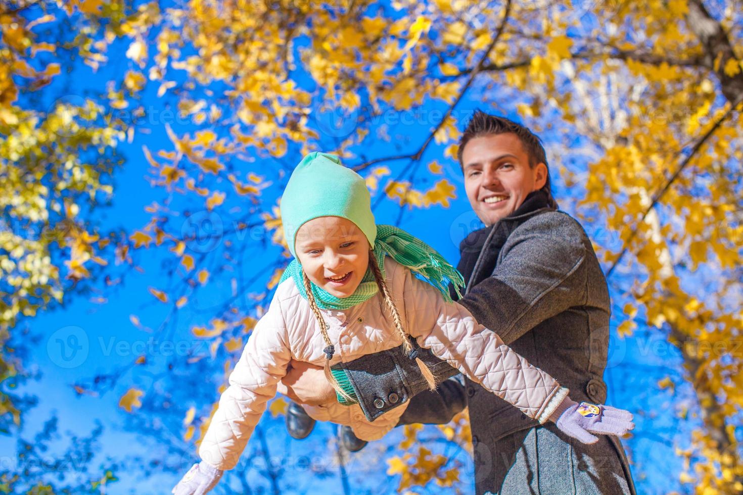 Cute little girl with happy daddy enjoy their autumn vacation on a sunny day photo