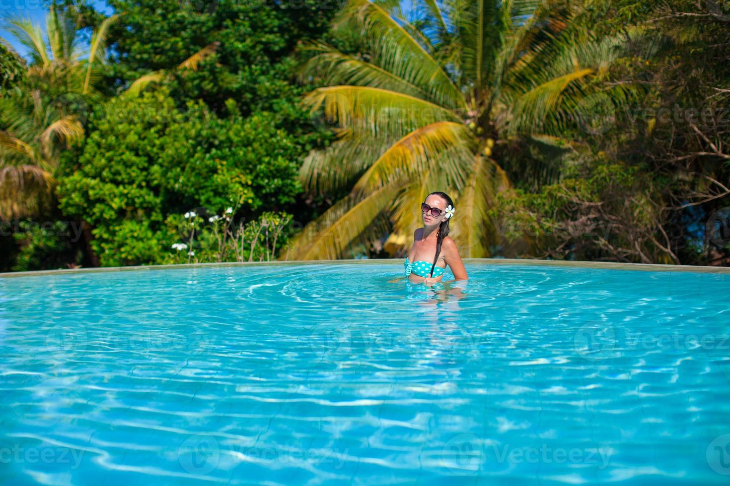 Young beautiful woman enjoying the luxury quiet swimmingpool photo