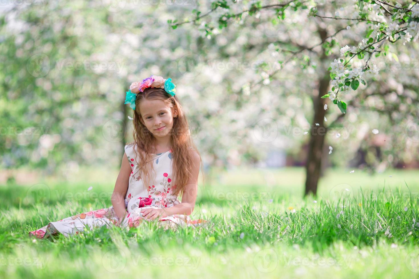 Little girl in blooming cherry tree garden outdoors photo