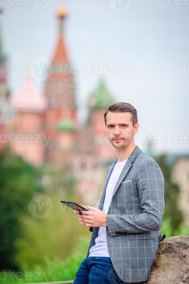 Happy young urban man drinking coffee in european city. photo