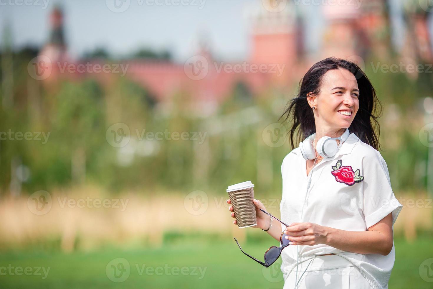 feliz joven mujer urbana tomando café en la ciudad europea. foto