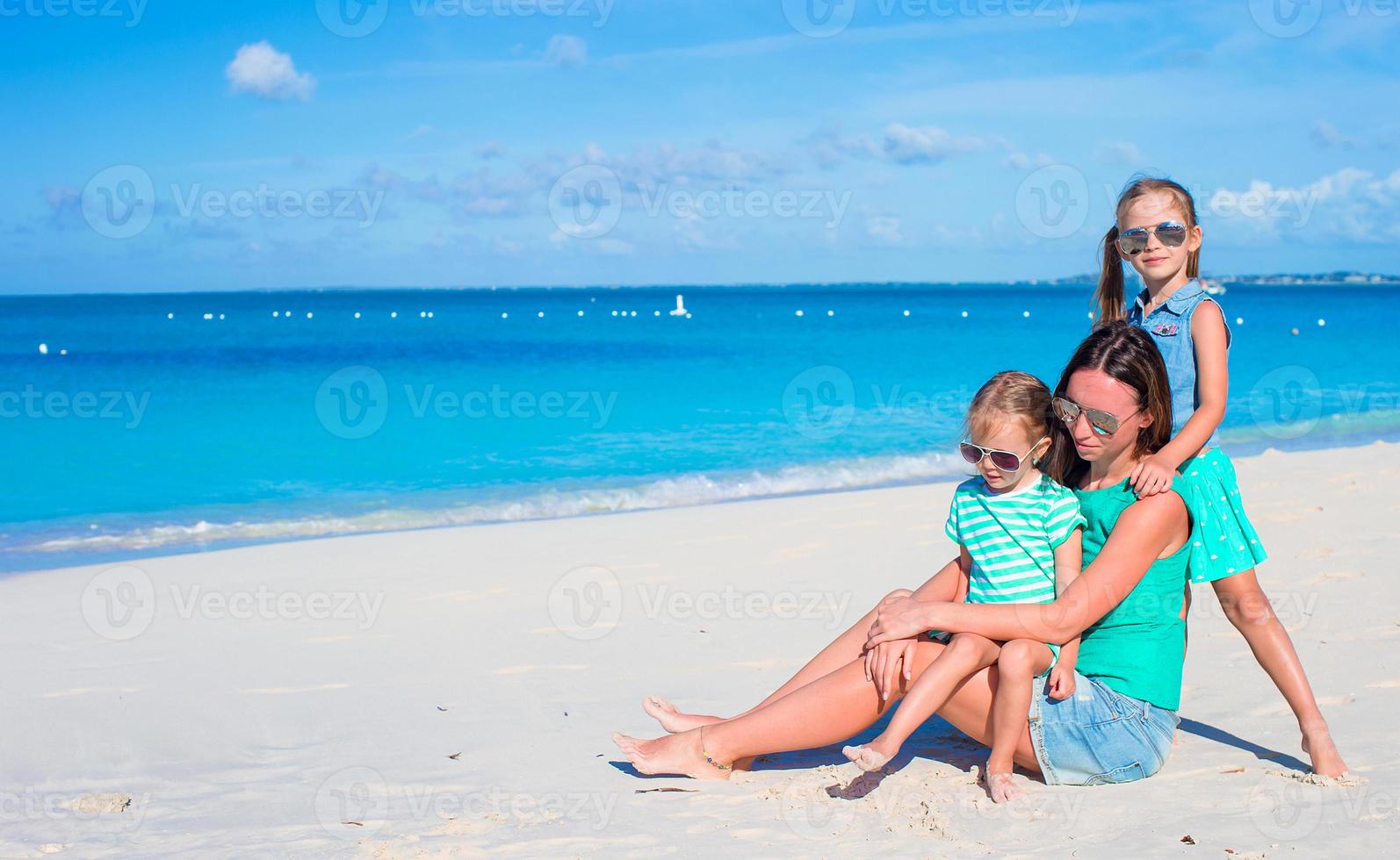 mamá y dos niñas durante las vacaciones en la playa foto