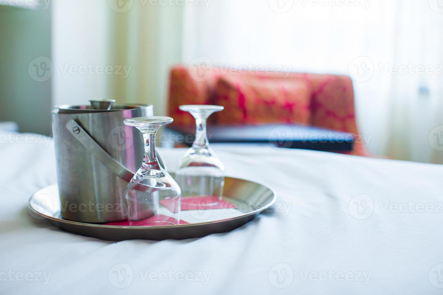 Romantic bedroom with wine glasses and ice bucket in luxury hotel interior photo