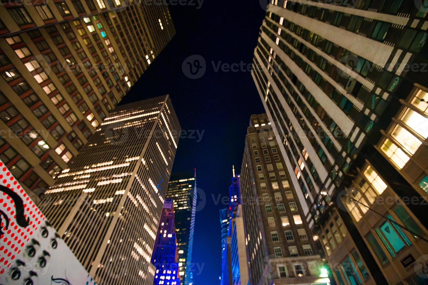 vista de los rascacielos de nueva york hacia arriba en la noche foto