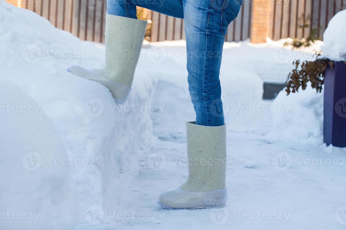 Close-up of warm boots for men's feet on the white snow photo