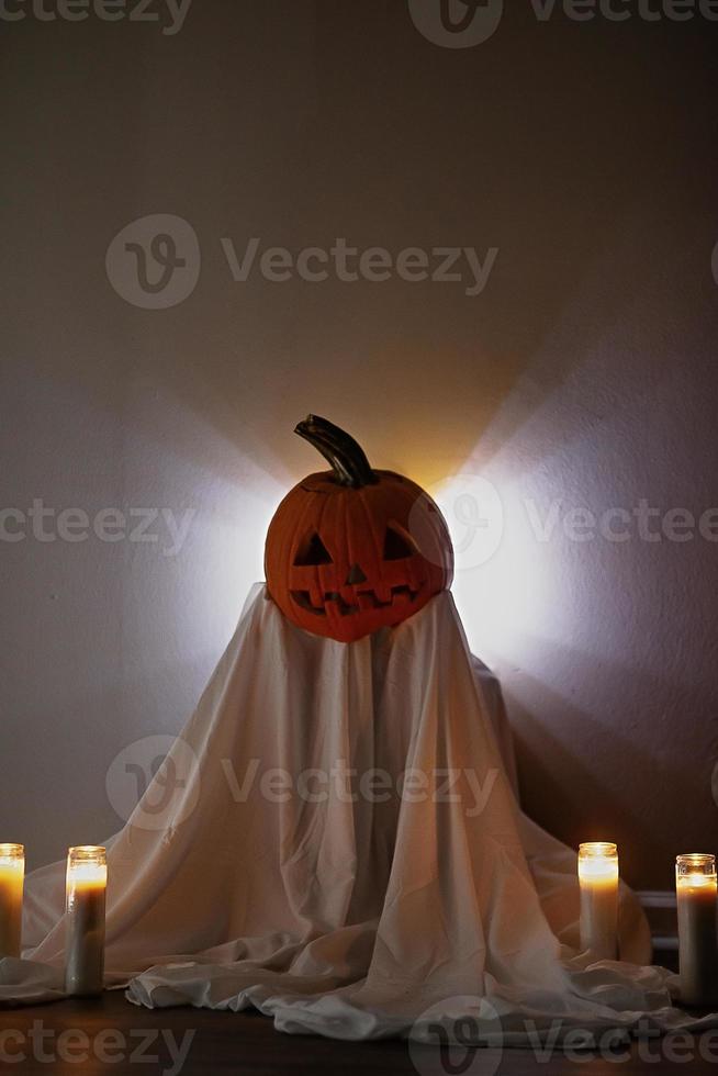 Kid with a pumpkin Jack o lantern for a head during a Halloween celebration photo