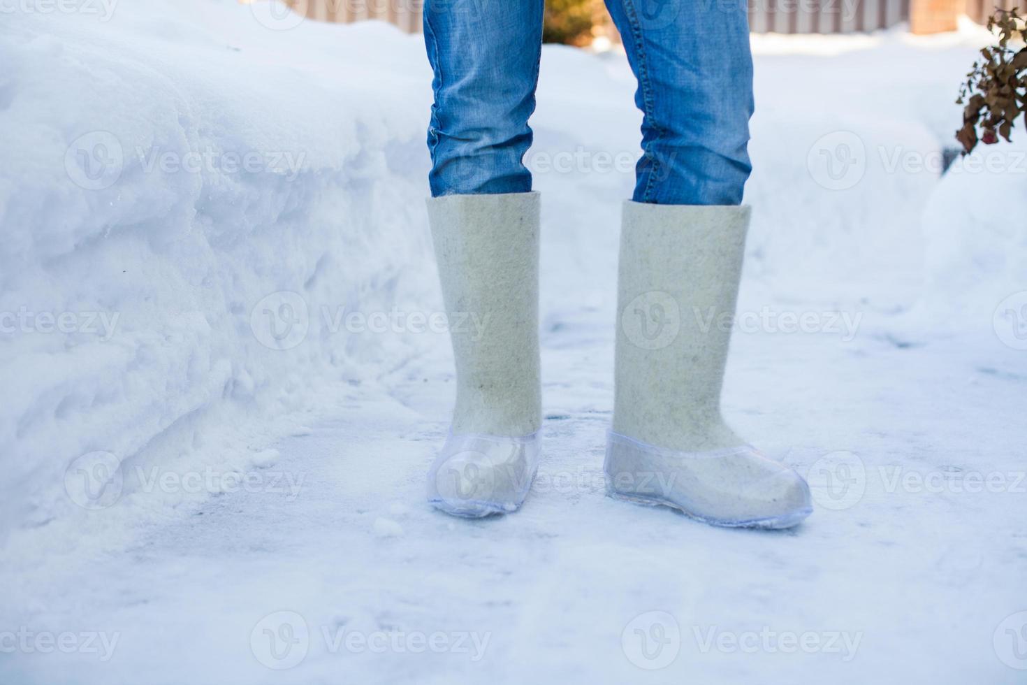 Close-up of warm boots for men's feet on the white snow photo