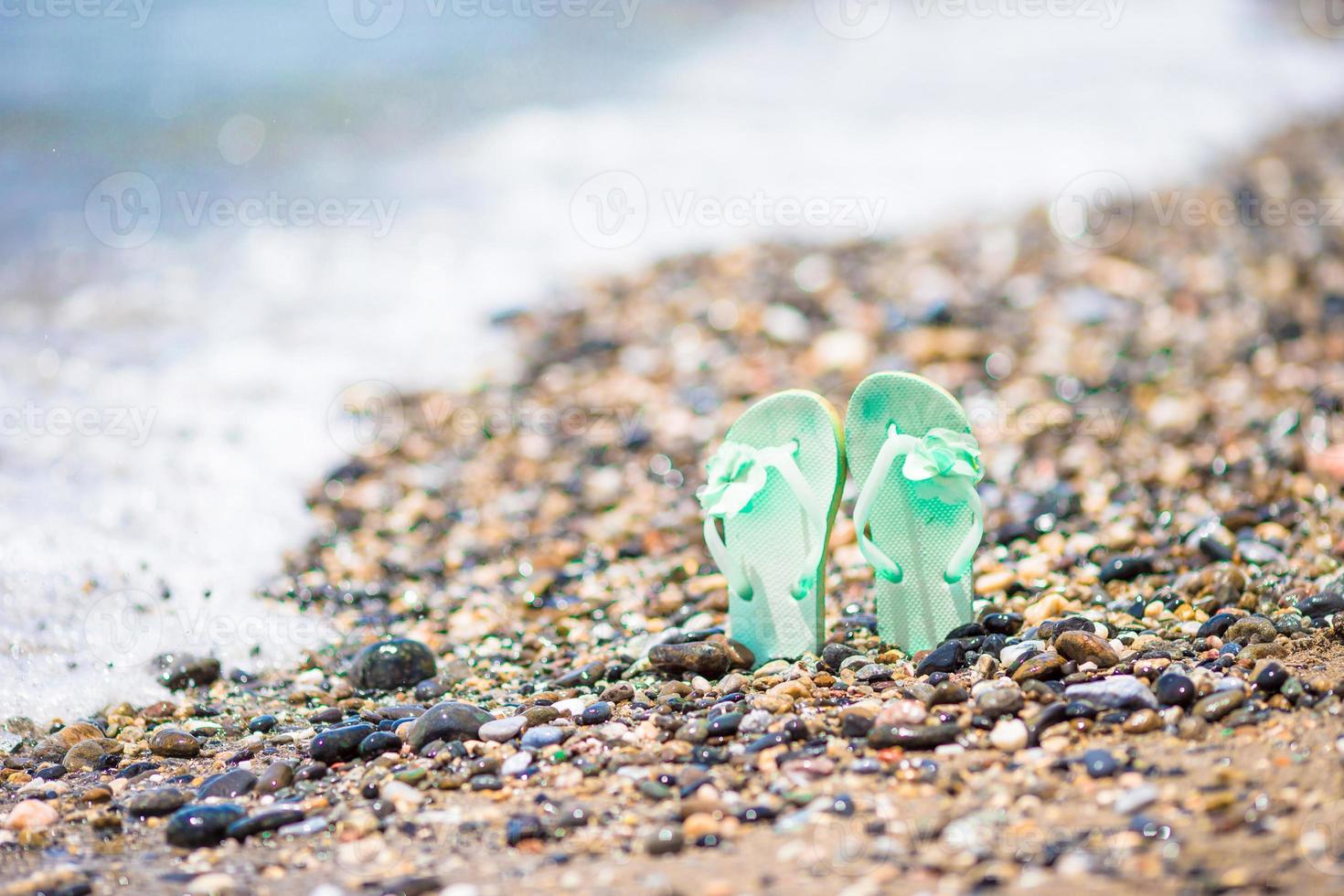 Kids flip flop on beach in front of the sea photo