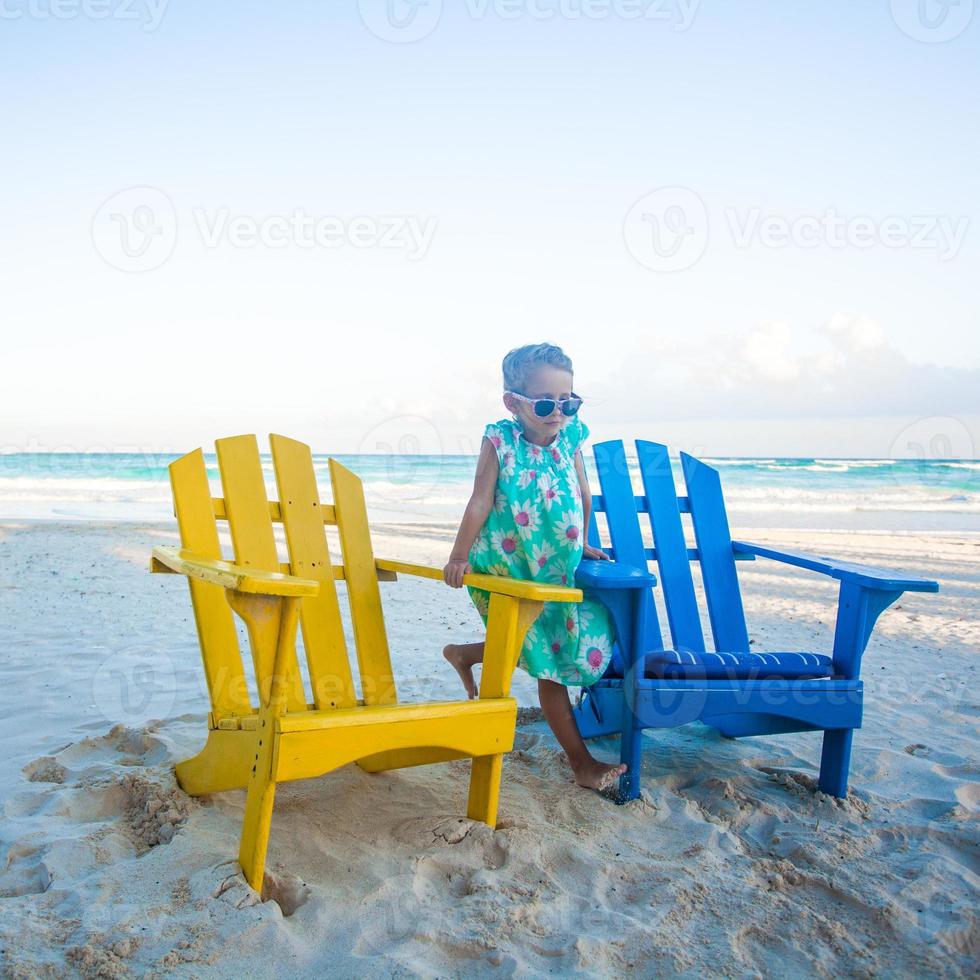 niña en la playa sillas coloridas de madera en la playa tropical de tulum, méxico foto