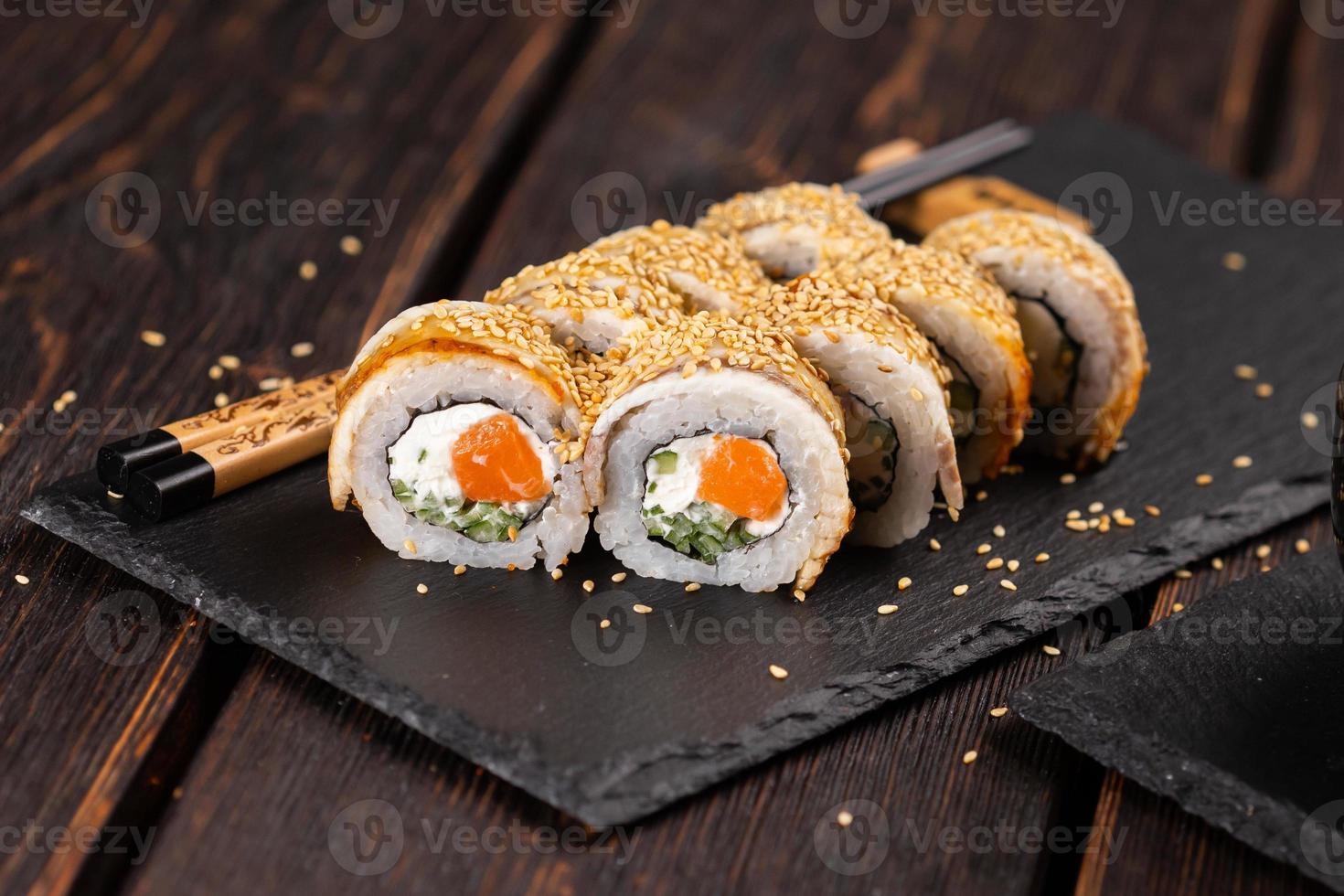 rollo de sushi con anguila ahumada y salmón con pepino y queso. delicioso juego de rollos de sushi fresco tradicional. menú de sushi restaurante de cocina japonesa. comida asiática foto