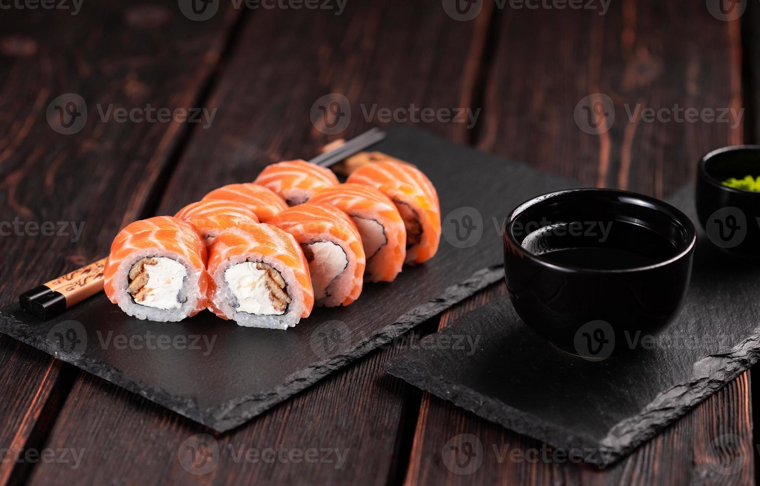 Sushi roll philadelphia with salmon and eel and cream cheese on black background close-up. Sushi menu. Japanese food concept photo