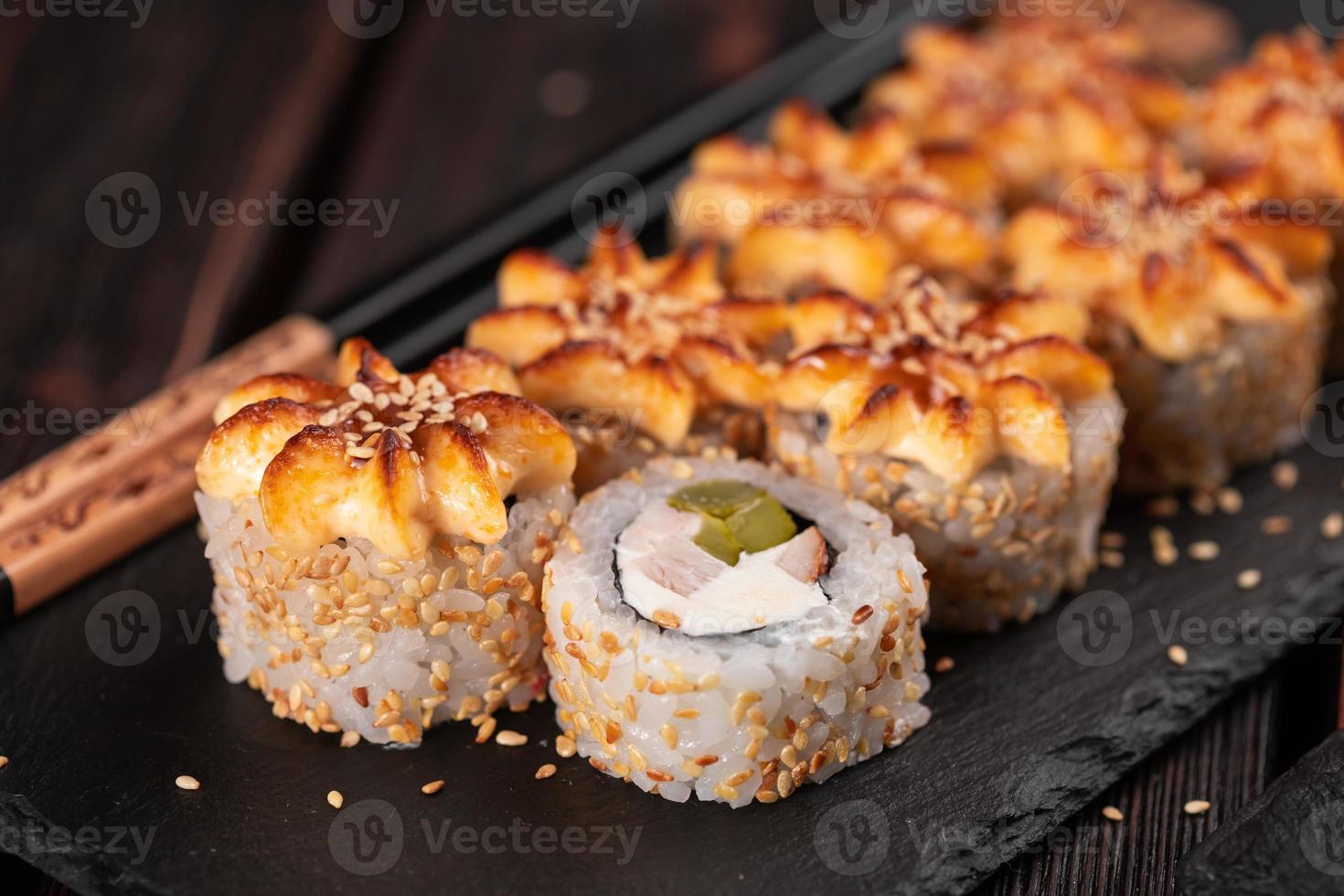 Sushi roll philadelphia with chicken avocado and cream cheese on black background close-up. Sushi menu. Japanese food concept photo