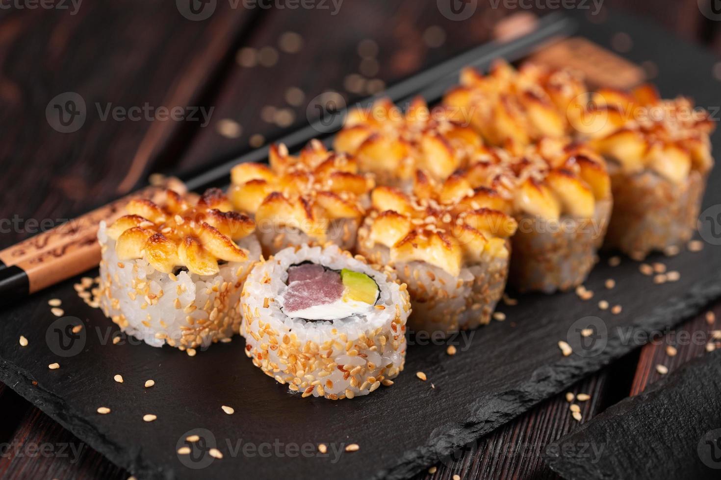 rollo de sushi con atún ahumado con primer plano de aguacate y queso. delicioso juego de rollos de sushi fresco tradicional. menú de sushi restaurante de cocina japonesa. comida asiática foto
