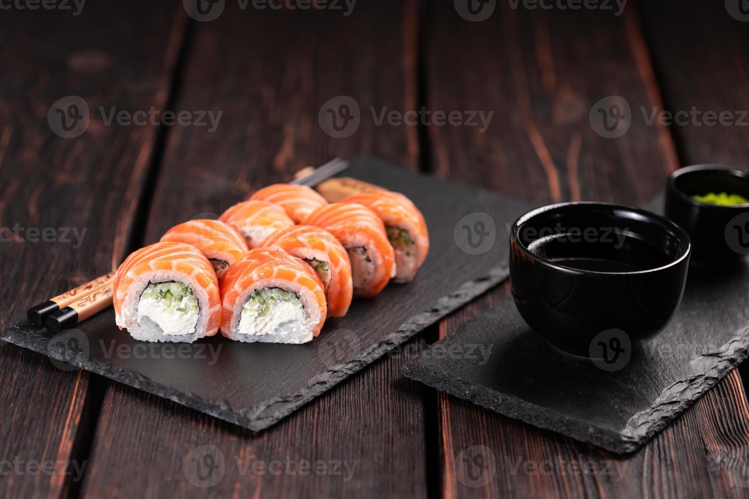 Sushi roll philadelphia with salmon and cream cheese on black background close-up. Sushi menu. Japanese food concept photo