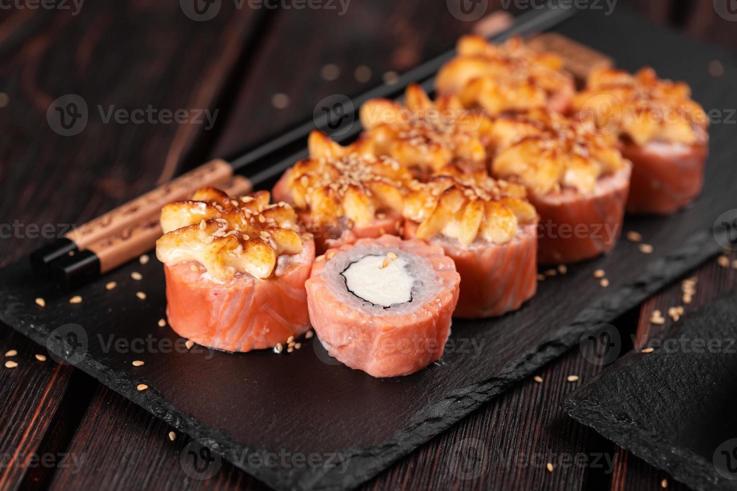 Sushi roll philadelphia with salmon and cream cheese on black background close-up. Sushi menu. Japanese food concept photo
