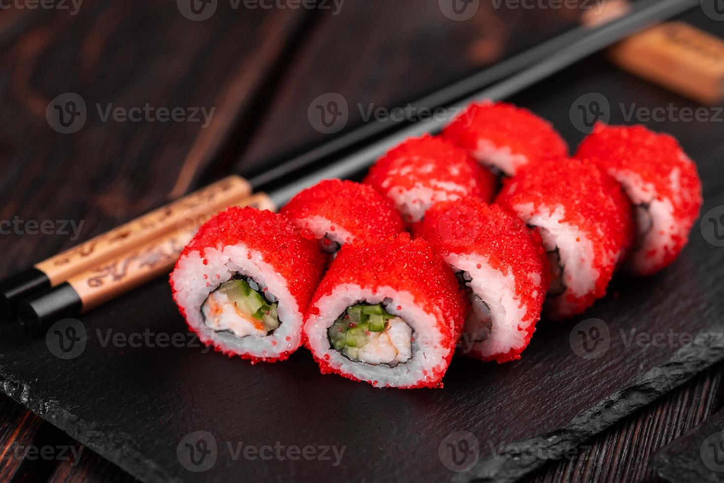 rollo de sushi con camarones y pepino y caviar tobiko servido en el primer plano de la pizarra - comida japonesa foto