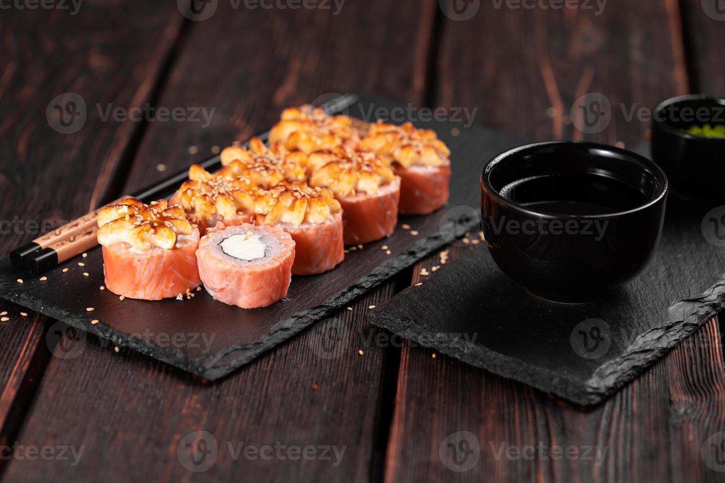 Sushi roll philadelphia with salmon and cream cheese on black background close-up. Sushi menu. Japanese food concept photo