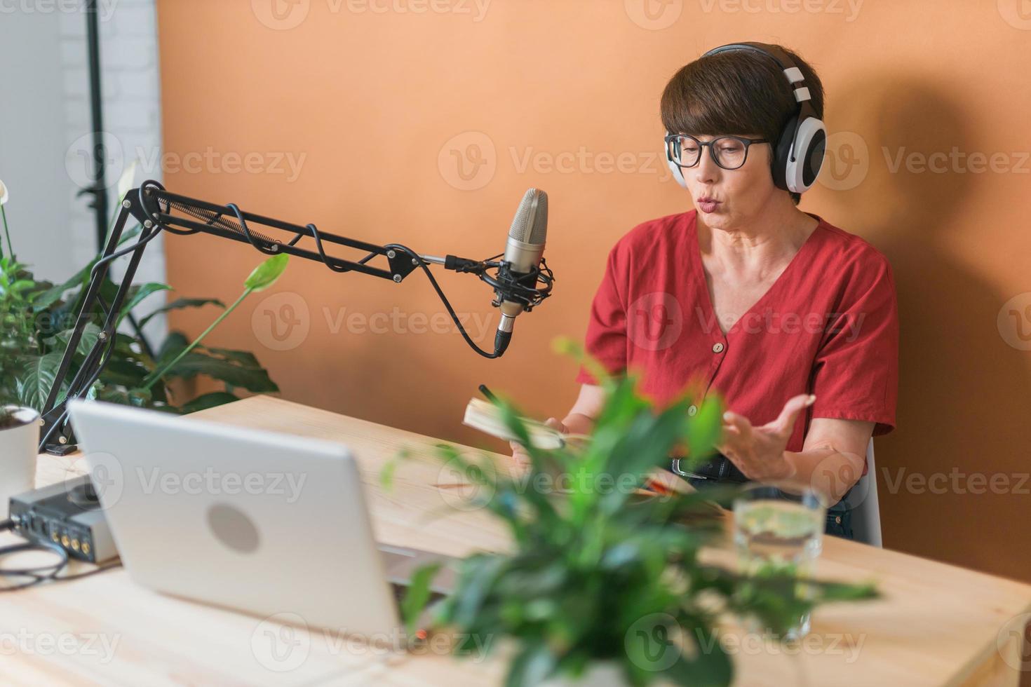 Middle-aged woman radio host making podcast recording for online show - broadcast and dj concept photo